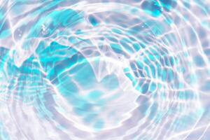 Bluewater waves on the surface ripples blurred. Defocus blurred transparent blue colored clear calm water surface texture with splash and bubbles. Water waves with shining pattern texture background. photo