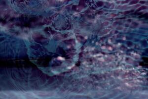 Bluewater waves on the surface ripples blurred. Defocus blurred transparent blue colored clear calm water surface texture with splash and bubbles. Water waves with shining pattern texture background. photo