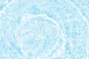 Bluewater waves on the surface ripples blurred. Defocus blurred transparent blue colored clear calm water surface texture with splash and bubbles. Water waves with shining pattern texture background. photo