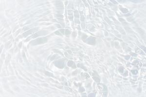Blue water with ripples on the surface. Defocus blurred transparent blue colored clear calm water surface texture with splashes and bubbles. Water waves with shining pattern texture background. photo