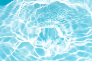 Bluewater waves on the surface ripples blurred. Defocus blurred transparent blue colored clear calm water surface texture with splash and bubbles. Water waves with shining pattern texture background. photo