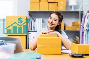 Portrait young attractive asia female owner startup business look at camera work happy with carton box at home prepare delivery to customers, procurement, omnichannel ecommerce online concept photo