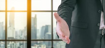 Business man is standing and open hand ready to seal a deal with city scape in background, partner shaking hands, shaking hands, copy space photo