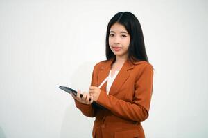 Young beautiful Asian woman in business office standing use tablet in hand, Thai girl enjoy browsing for online shopping store with copy space for advertisement, on isolated white background photo
