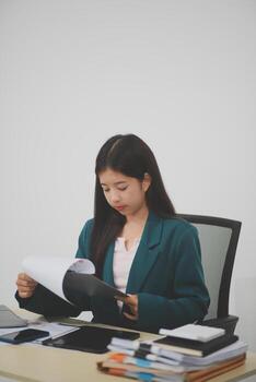 Asian business woman working using laptop computer, marketing report with calculator document on table Planning to analyze financial reports Investing in an online business plan, e-commerce. photo