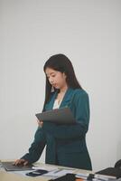Asian Business woman using calculator and laptop for doing math finance on an office desk, tax, report, accounting, statistics, and analytical research concept photo