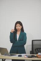 Asian Business woman using calculator and laptop for doing math finance on an office desk, tax, report, accounting, statistics, and analytical research concept photo