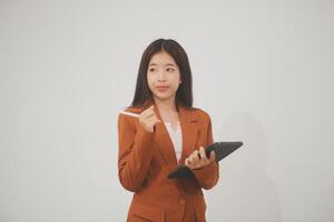 Young beautiful Asian woman in business office standing use tablet in hand, Thai girl enjoy browsing for online shopping store with copy space for advertisement, on isolated white background photo