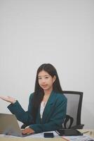 Beautiful Asian businesswoman work using a tablet and a laptop with documents placed at the office. photo