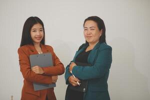 Two young professional women looking at a digital tablet isolated on white background photo