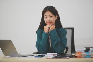 Asian Business woman using calculator and laptop for doing math finance on an office desk, tax, report, accounting, statistics, and analytical research concept photo