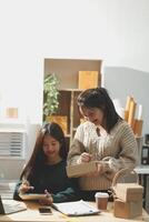 Startup small business SME, Entrepreneur owner African woman using smartphone or tablet taking receive and checking online purchase shopping order to preparing pack product box. photo