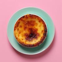 Creme brulee on blue plate with pink background. photo