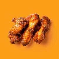 Close-Up of Crispy Chicken Wings on an Orange Background photo