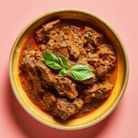 Beef Curry with Basil Garnish in a Yellow Bowl photo