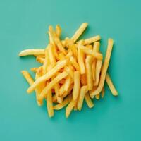 Golden French Fries on Turquoise Background photo