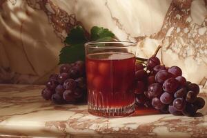 Glass of Grape Juice with Grapes on Marble Background photo