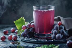 Glass of Grape Juice with Grapes and a Leaf photo