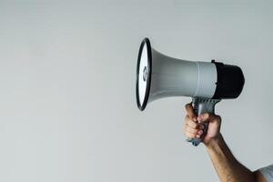 Hand holding a megaphone on a white background photo