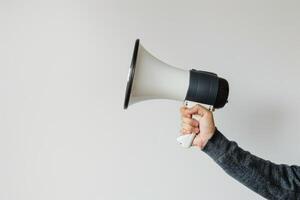 Hand holding a megaphone on a white background photo