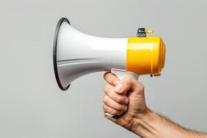 Hand holding a megaphone on a neutral background photo