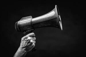 Vintage Megaphone Held in Hand on Dark Background photo