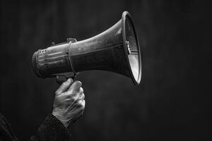 Elderly hand holding a megaphone to amplify voice photo