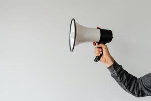 Hand holding a megaphone on a white background photo