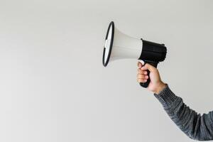 Hand holding a megaphone with a blank background for text photo