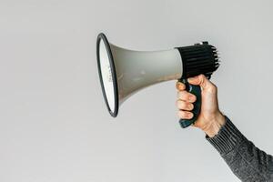 Hand holding a megaphone on a white background photo