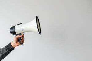 Hand holding a megaphone on a white background photo