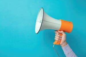 Hand holding a megaphone on blue background photo