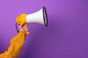 Pink megaphone in hand against purple wall background photo