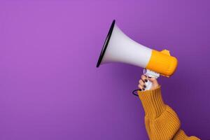 Pink megaphone in hand against purple wall background photo
