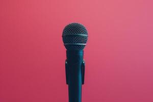 Close up of a microphone on stage with pink background lights photo