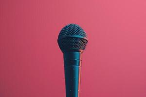 Close up of a microphone on stage with pink background lights photo