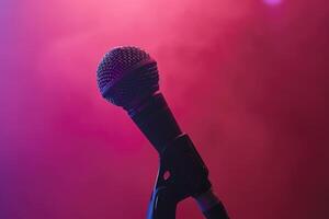 Close up of a microphone on stage with a pink background photo