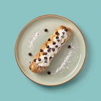 Delicious chocolate chip pastry with cream filling on a plate. Top view of dessert with powdered sugar and chocolate chips. Concept of bakery, pastry, food, sweet, and dessert photo