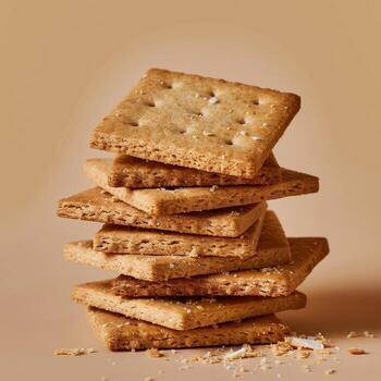 Close up of a stack of square shaped crackers with sea salt on top and a beige background. Concept for delicious snack or food photography. photo