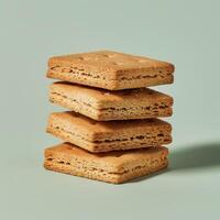 Stack of four square crackers isolated on a blue background photo
