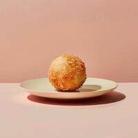 Closeup of a golden, crispy, deep-fried ball of dough on a white plate, perfect for a dessert or snack. photo