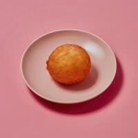 Golden brown donut on pink plate against a pink background, freshly baked, delicious, pastry, bakery, dessert, sweet treat. photo