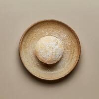 Closeup of a round mochi dessert with white coconut flakes. Traditional Japanese snack food on a rustic plate. photo