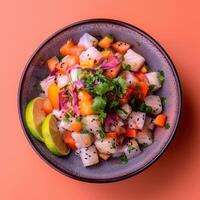 Freshly made ceviche with diced fish, red onions, tomatoes, cilantro, lime, and chili peppers in a gray bowl. Concept of delicious Latin American seafood dish. photo