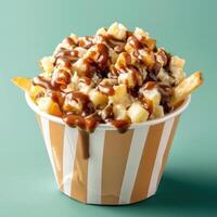 Closeup of delicious poutine, a Canadian dish of french fries topped with cheese curds and gravy. Classic comfort food. photo