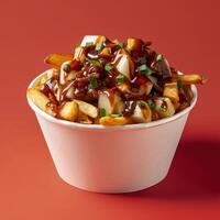 Close-up of a delicious poutine dish in a white bowl with fries, cheese curds, gravy and green onions. photo