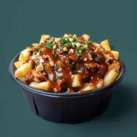 Delicious Poutine with Gravy, Cheese Curds and Toppings in Black Bowl on Green Background photo
