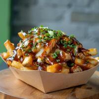Close-up of cheesy poutine fries with barbecue sauce, cheese curds, and green onions in a paper bowl. Delicious, messy, and indulgent fast food for lunch or dinner. photo