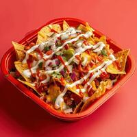 Close up of a plate of loaded nachos with ground beef, cheese, jalapenos, red onion, sour cream, and barbecue sauce. A perfect snack or meal. photo