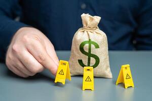 A man surrounds a dollar money bag with restrictive signs. The concept of sanctions and restrictions. Freezing of capital, seizure of funds. Limitation on use of dollar transactions. Dedollarization. photo